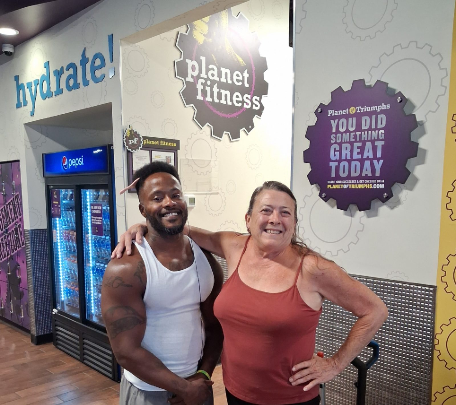 Tony Bess smiling with a training client at the gym